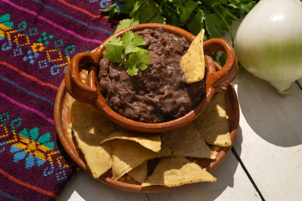 fagioli fritti messicani con totopos su sfondo bianco - frijoles foto e immagini stock
