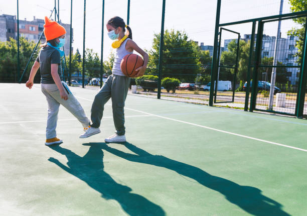 istock Two children with face protective masks using foot bump. High five without hands 1292004096