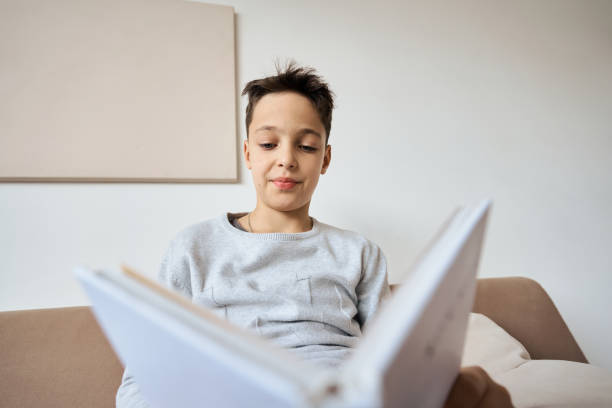 istock Caucasian boy reading book at home 1292004777