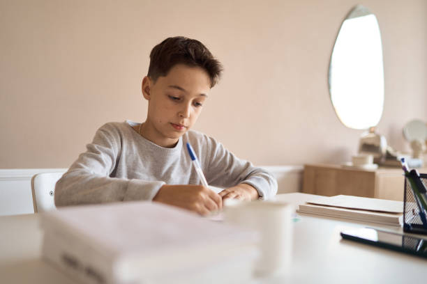 istock Distance learning online education. A schoolboy boy studies at home and does school homework. A home distance learning. 1292004855
