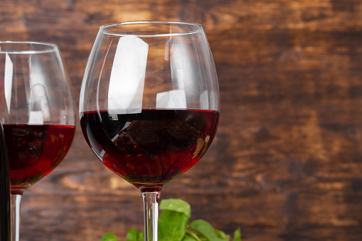 Two wine glasses against dark wooden background close up
