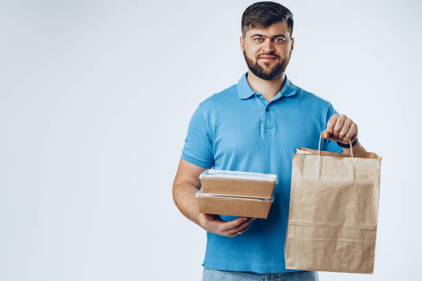 istock Food delivery courier with order on grey background 1292006479
