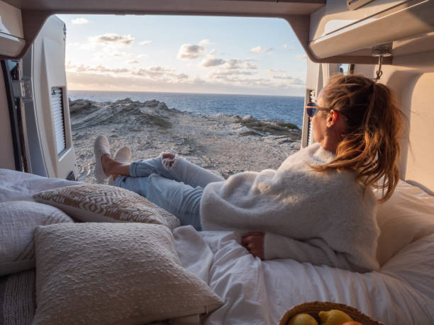 istock Woman lying at the back of a van looking at ocean 1292006556