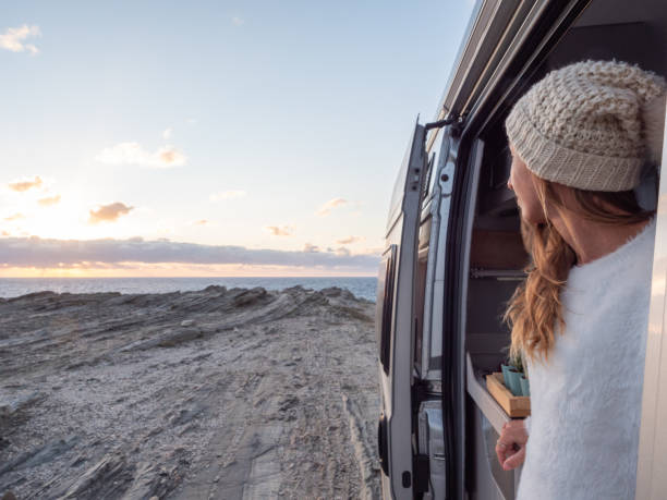 istock Woman looks at coastline from her van 1292006566
