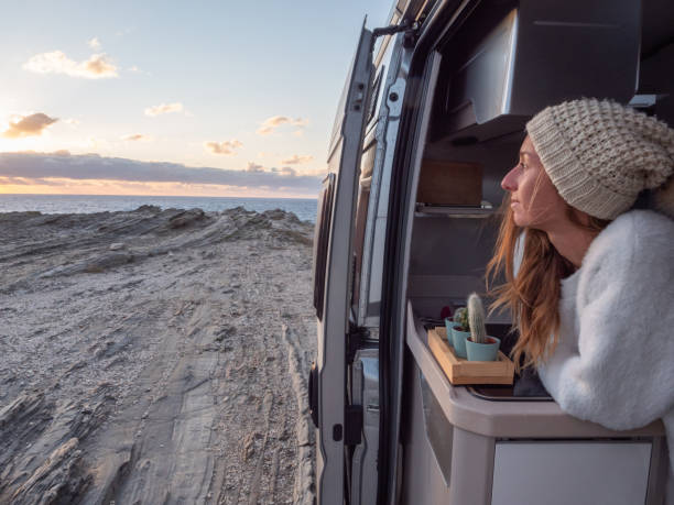 istock Woman looks at coastline from her van 1292006581