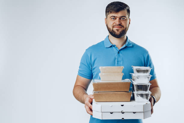 istock Food delivery courier with order on grey background 1292010519
