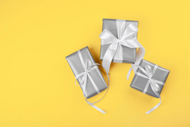 istock Attractive gray gifts on the yellow background 1292013437