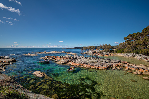 Binalong Bay, Australia - April 9, 2019: The famous orange lichen-cloaked boulders, white sand beaches and clear waters of the Bay of Fires along the east coast of Tasmania.