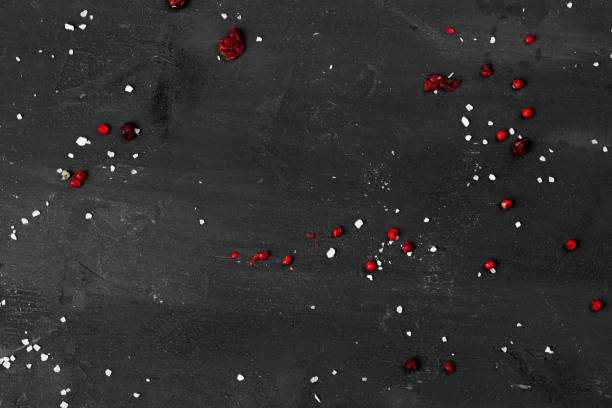 istock Black stone background with scattered spices, top view 1292019696