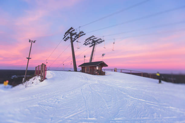 beautiful cold mountain view of ski resort, sunny winter day with slope, piste and ski lift, with group of mountain downhill skiers and snowboarders - apres ski snow winter european alps imagens e fotografias de stock