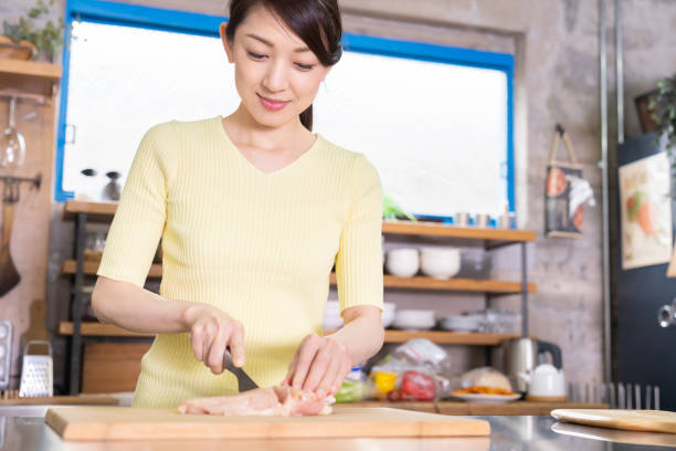 asian woman cooks in a kitchen,chicken - white meat flash imagens e fotografias de stock