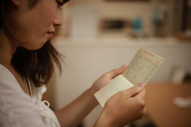 istock A woman who is worried about looking at her passbook 1292027298