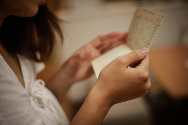 istock A woman who is worried about looking at her passbook 1292027317