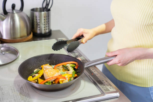 istock asian woman cooks in a kitchen,hands,saute 1292027345