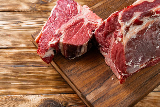 istock Raw T-bone steak with herbs on wooden board 1292029834