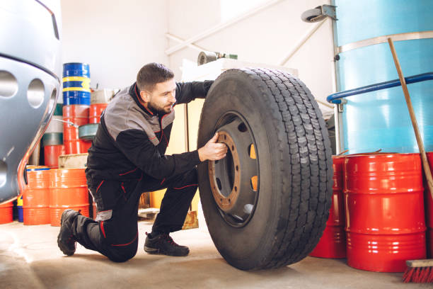 meccanico che cambia ruota dell'autobus nell'officina di riparazione. - truck tire foto e immagini stock