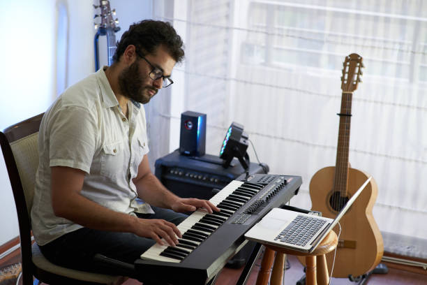istock musician playing piano while recording from his home studio 1292030791