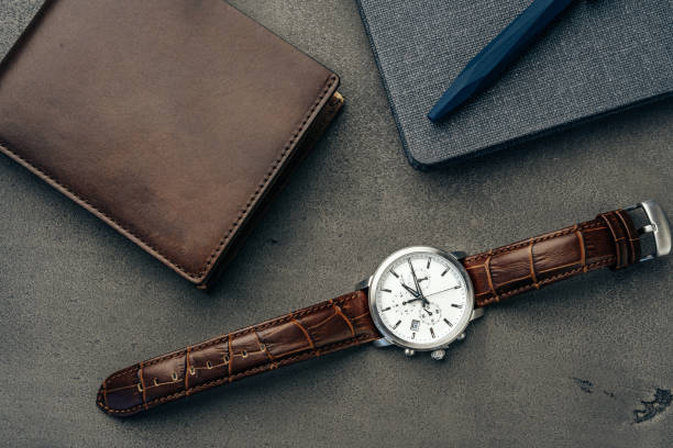 istock Male watch and leather wallet on dark grey surface 1292035002