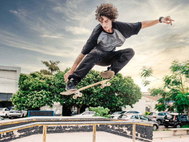 Professional skateboarder performing maneuver in the air on urban track stock photo