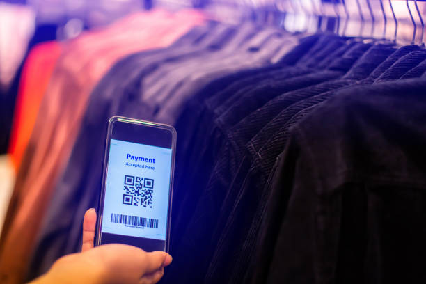 istock Selective focus to payment QR code tag on smartphone with blurry many clothes in the store to accepted generate digital pay without money. 1292040206