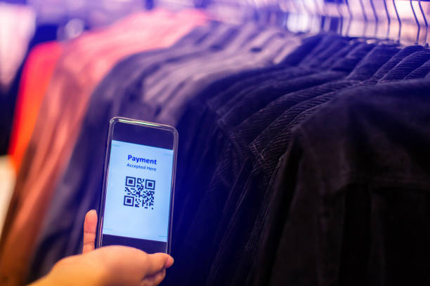 istock Selective focus to payment QR code tag on smartphone with blurry many clothes in the store to accepted generate digital pay without money. 1292040207