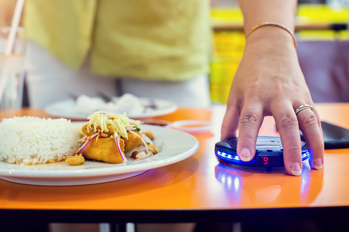 Máquina de llamada de cola inalámbrica en la mano del cliente con alimentos. Sistema de llamadas inalámbricas de paginación de cola con alarma de luz roja para restaurante photo