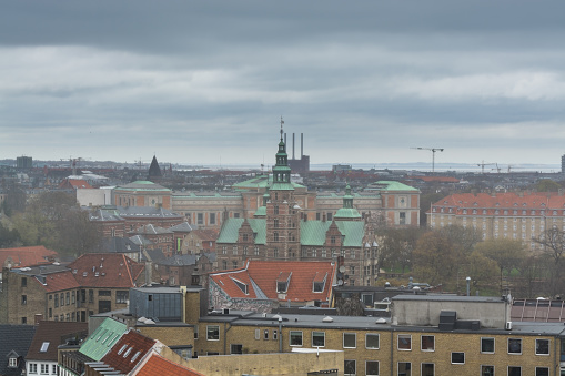 Aerial view of old downtown of Copenhagen City from the The Round Tower (Rundetaarn) in rainy misty day with cloudy sky with red house roofs and churches
