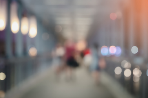 Blur abstract background image of city passage with people walking at night illuminated