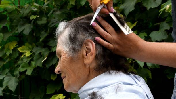 istock Senior woman cutting hair at home while quarantine 1292048205