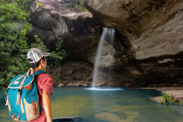 Young man traveler with a backpack at saeng chan waterfall, beautiful waterfall in Ubon Ratchathani, Thailand.