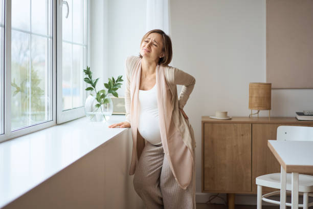 ヘルスケア、治療。若い妊婦は背中に突然の痛みを感じています。背中の痛みに苦しむ将来のお母さん。 - human pregnancy backache massaging back ストックフォトと画像