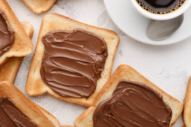 istock Bread toast with chocolate-nut paste spread and a cup of coffee: a nutritious snack 1292059543