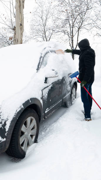 istock A man streams icy snow from a car with a plastic shovel. 1292068644