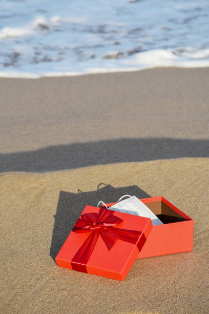 istock Protective face mask in a gift box on the sandy beach 1292069639