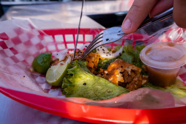 istock Hands cutting a vegetarian fried taco on plastic basket 1292069682