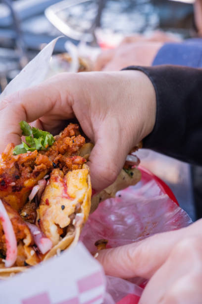 istock Female hand holding a vegetarian taco above a plastic basket 1292070459