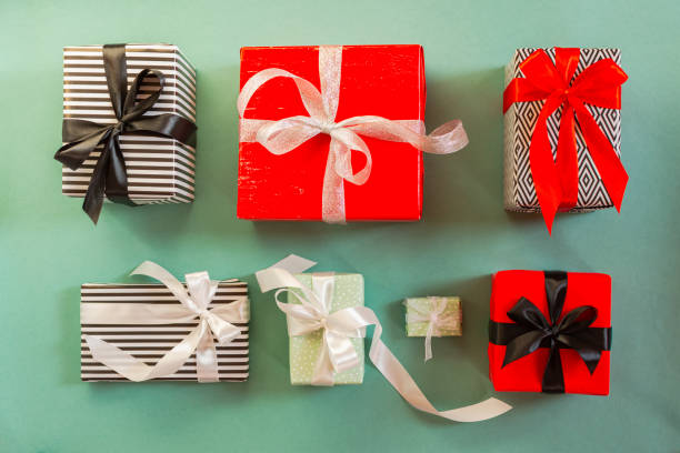istock Christmas gifts on a green background. Different packed boxes with tied bows top view. 1292074385