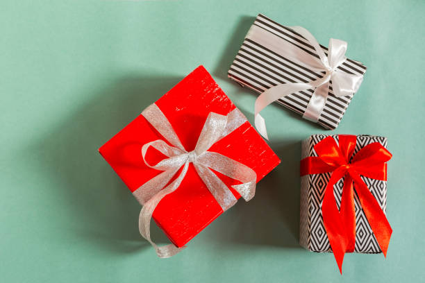 istock Christmas gifts on a green background. Different packed boxes with tied bows top view. 1292074387