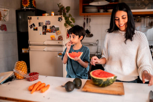 istock Mother and son eating watermelon 1292075135