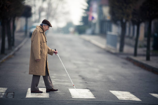 Blind man crossing a street Blind man crossing a street blindness stock pictures, royalty-free photos & images