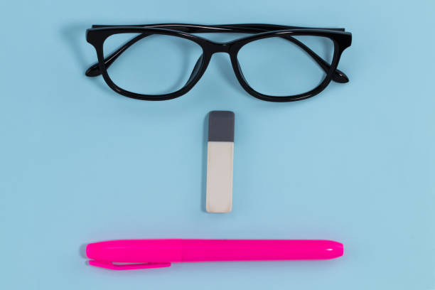 istock glasses eraser and pen on blue background education concept. abstract face 1292076676