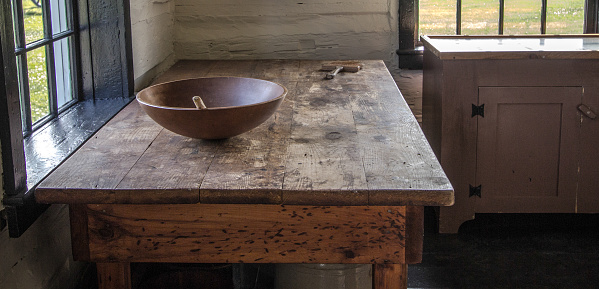 Pioneer style rustic rural country kitchen with empty wooden table and bowl.