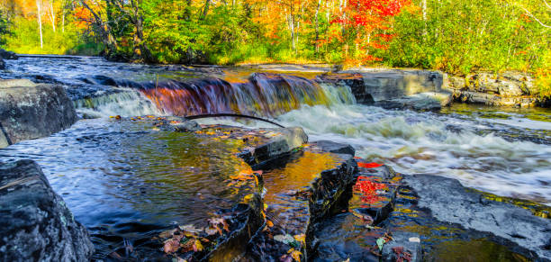 Michigan Autumn Waterfall Landscape In Panoramic Orientation Canyon Falls along US 41 at peak fall colors in the Upper Peninsula of Michigan. michigan photos stock pictures, royalty-free photos & images