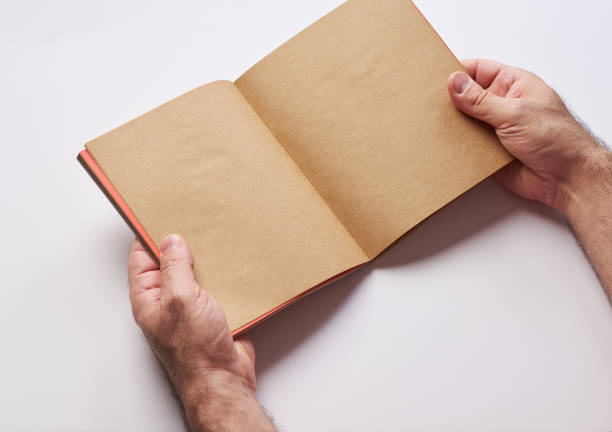 istock clear blank notebook on a white background and two hands are holding it 1292090389