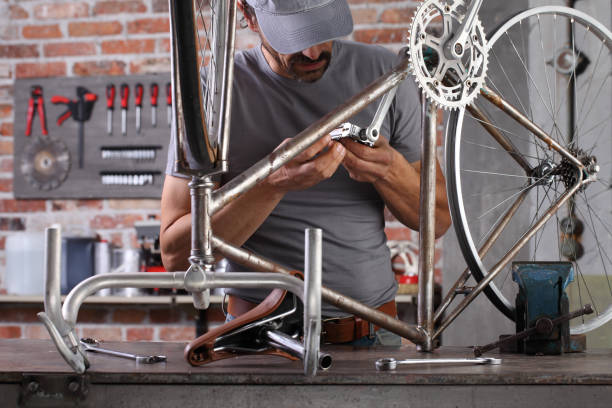 istock man repair the vintage bicycle in garage workshop on the workbench with tools, diy concept 1292096372
