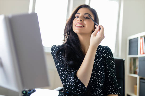 istock Young woman applying make up at her home 1292097655