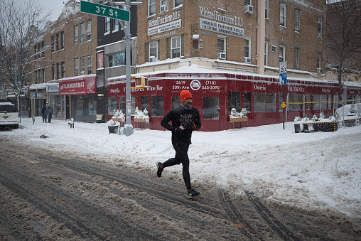 Queens, New York. December 17, 2020. A man jogging during a winter storm in Astoria.