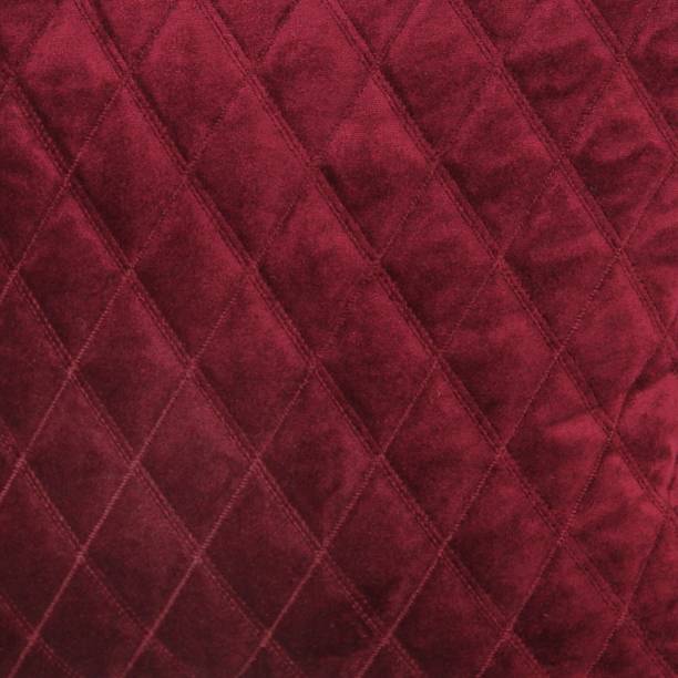 istock Wine red diamond quilted velvet fabric texture 1292100078