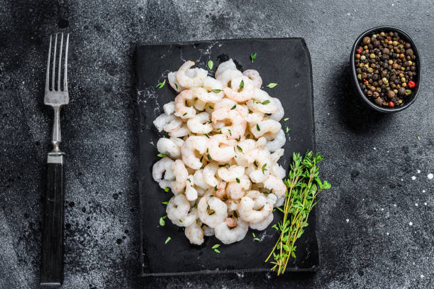 istock Peeled Shrimps, Prawns on a marble board. Black background. top view 1292100252