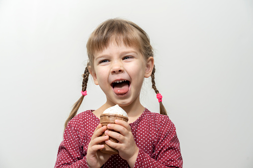 happy little caucasian girl eating ice cream.
